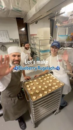 Bakery staff preparing trays of dough squares for blueberry rugelach in a commercial kitchen at Breads Bakery – Union Square.