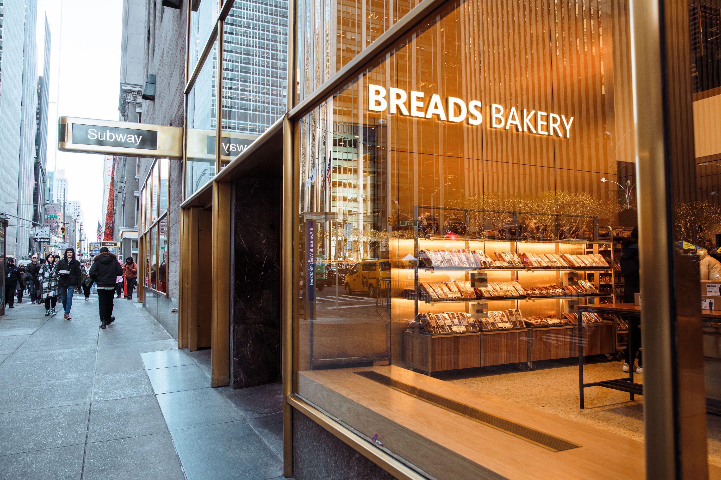 Breads Bakery at Rockefeller Center features a modern storefront with fresh pastries and breads visible inside.