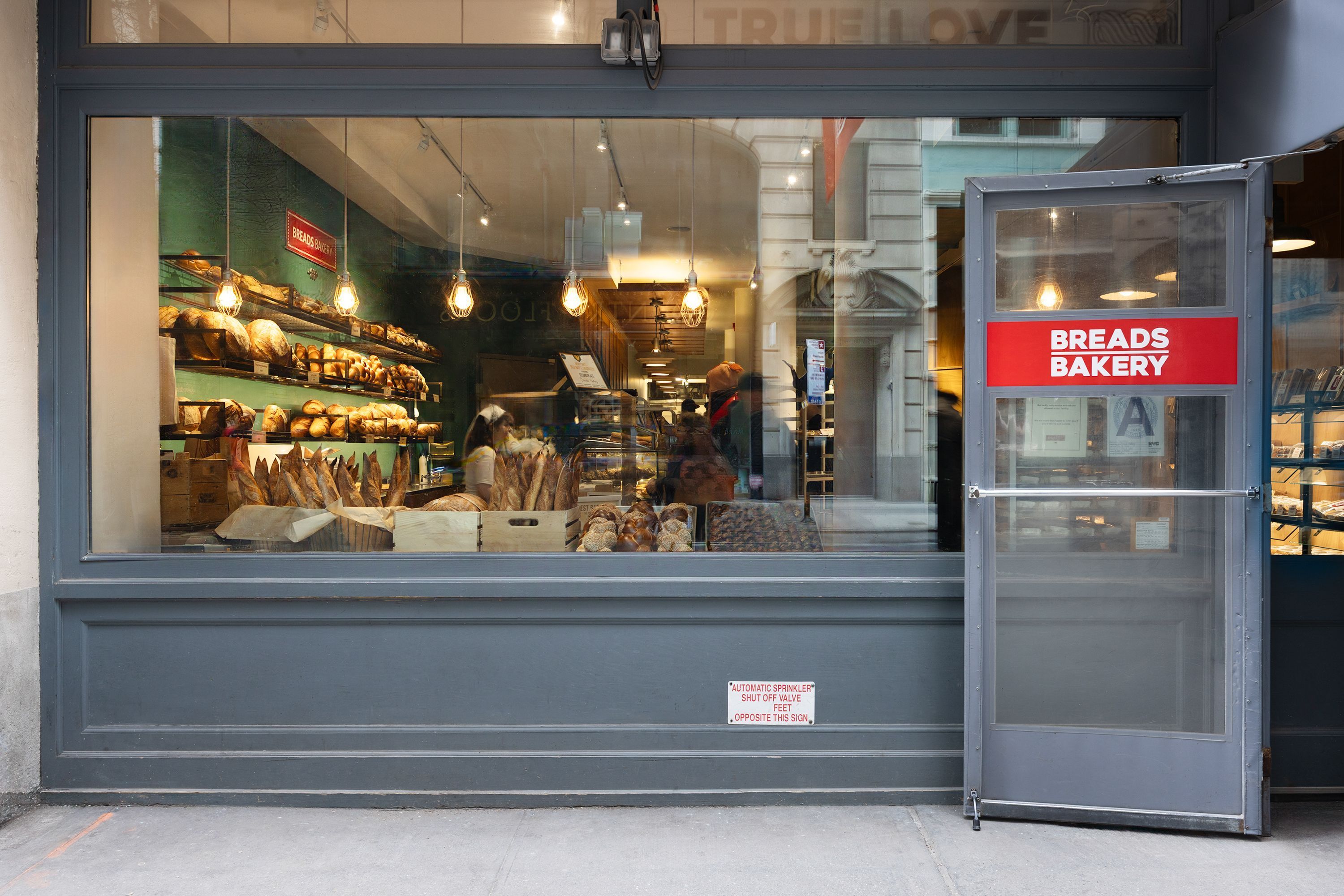 Breads Bakery features a display of various breads, pastries, and baked goods visible from the street.