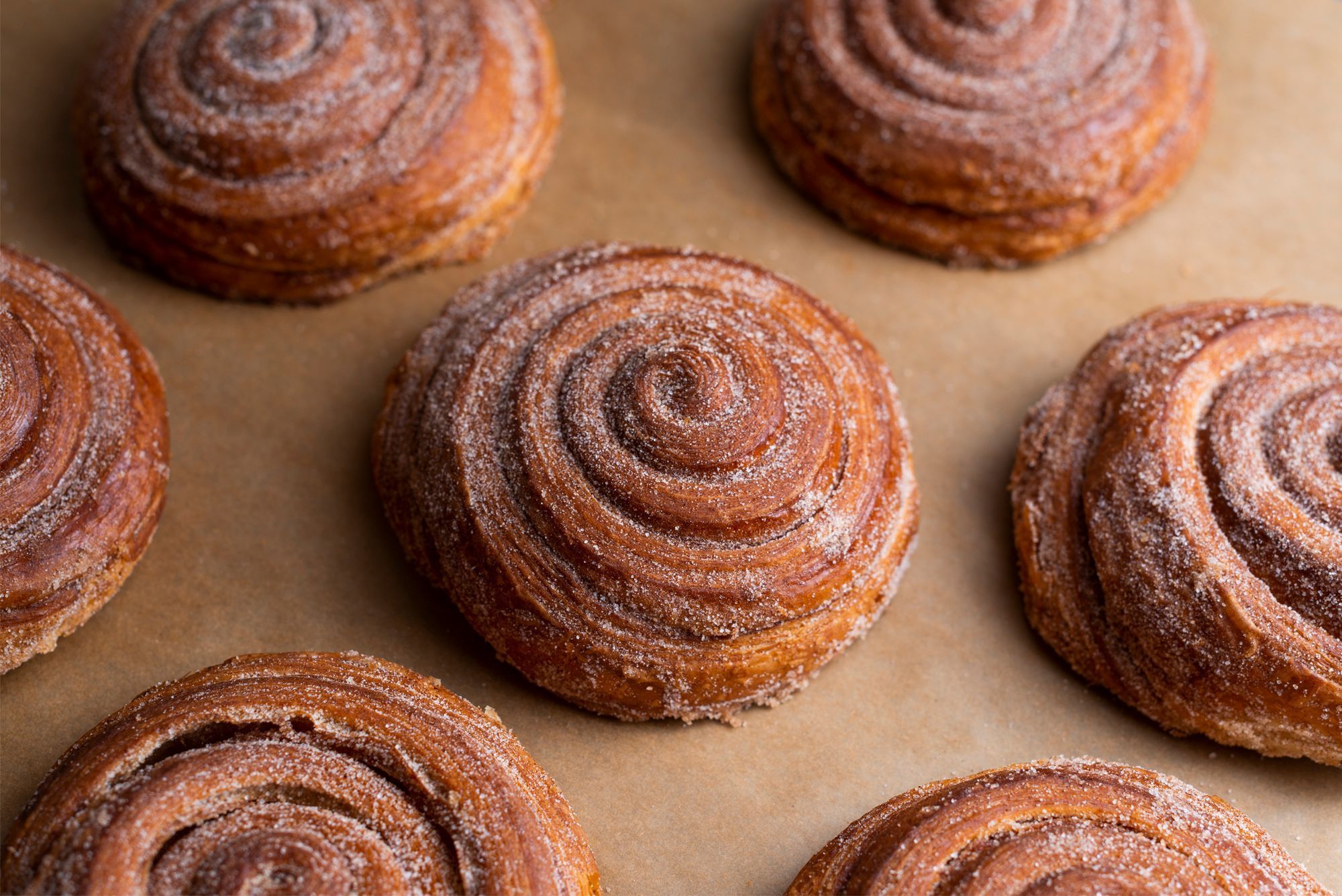 Delicious cinnamon pastries arranged neatly on a baking sheet, showcasing their golden-brown color.
