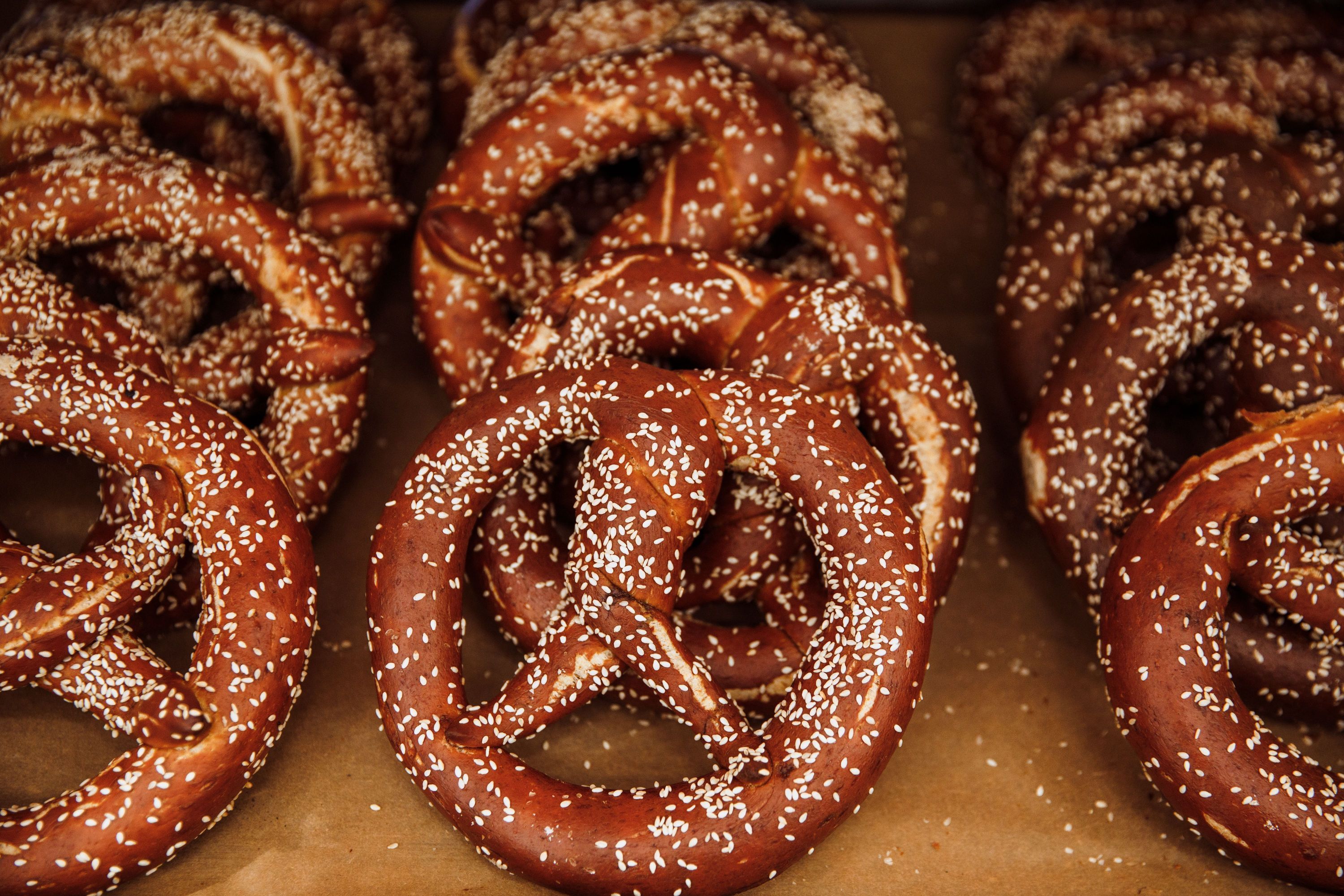 Freshly baked pretzels topped with sesame seeds, available at Breads Bakery – Rockefeller Center.