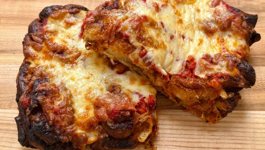 Freshly baked pastry topped with melted cheese and rich tomato sauce, perfect for lunch.