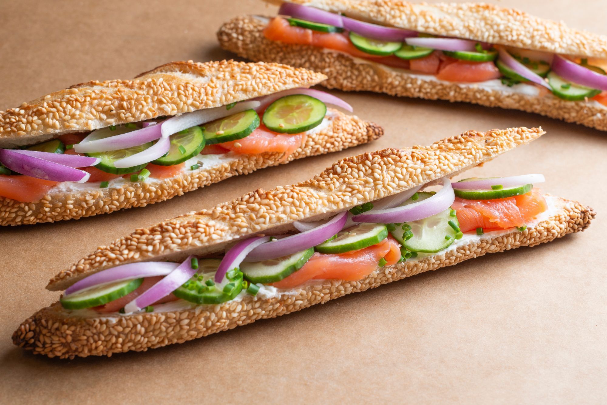 Fresh sesame sandwich filled with smoked salmon, cucumbers, onions, and jalapeños.