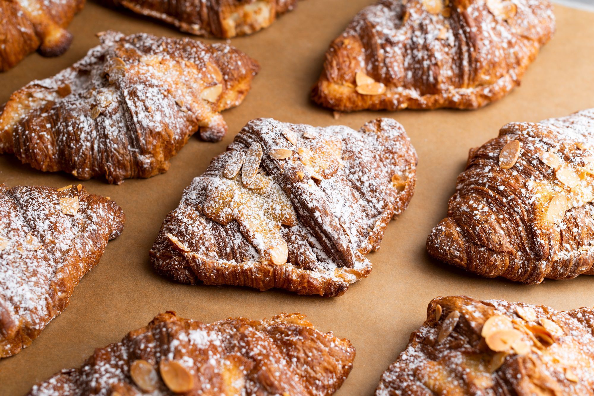 Delicious pastries with powdered sugar and almond slices, freshly baked and served at Breads Bakery.